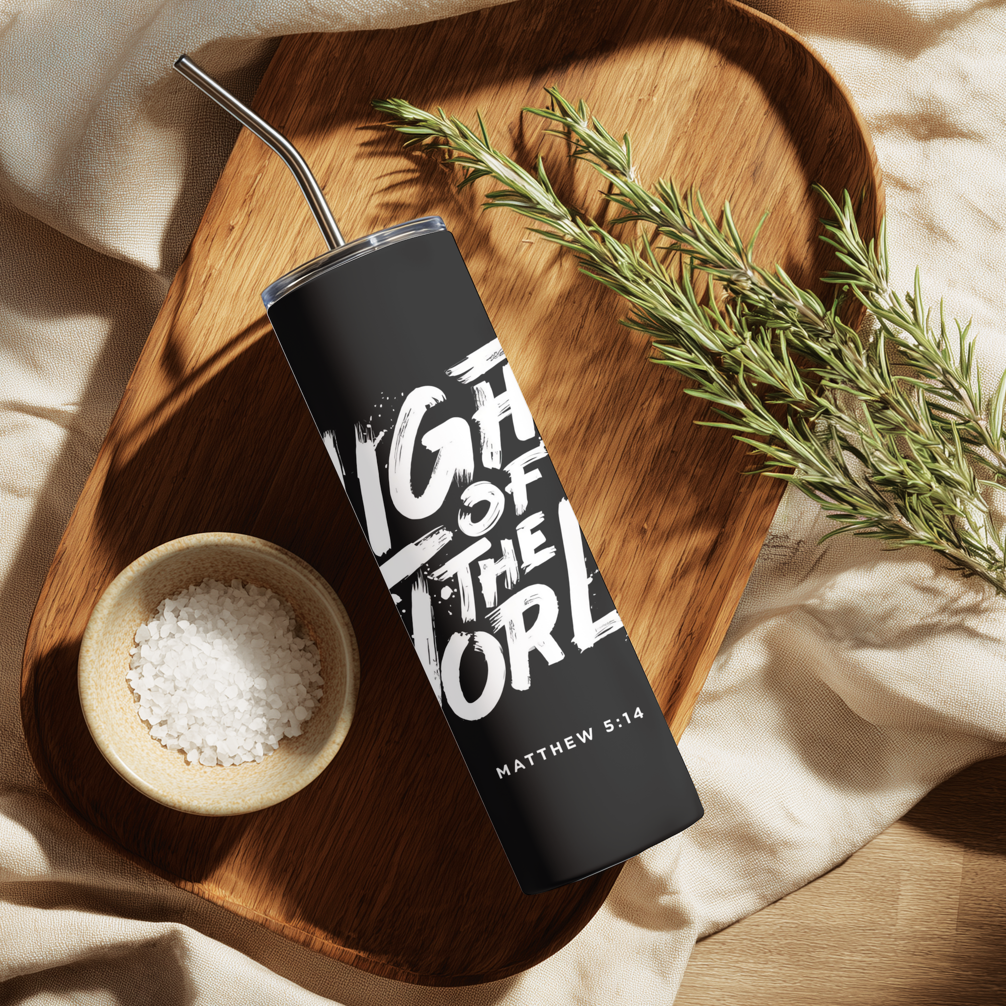 Lifestyle image of Light of the World™ tumbler styled in a cozy setting with warm tones.