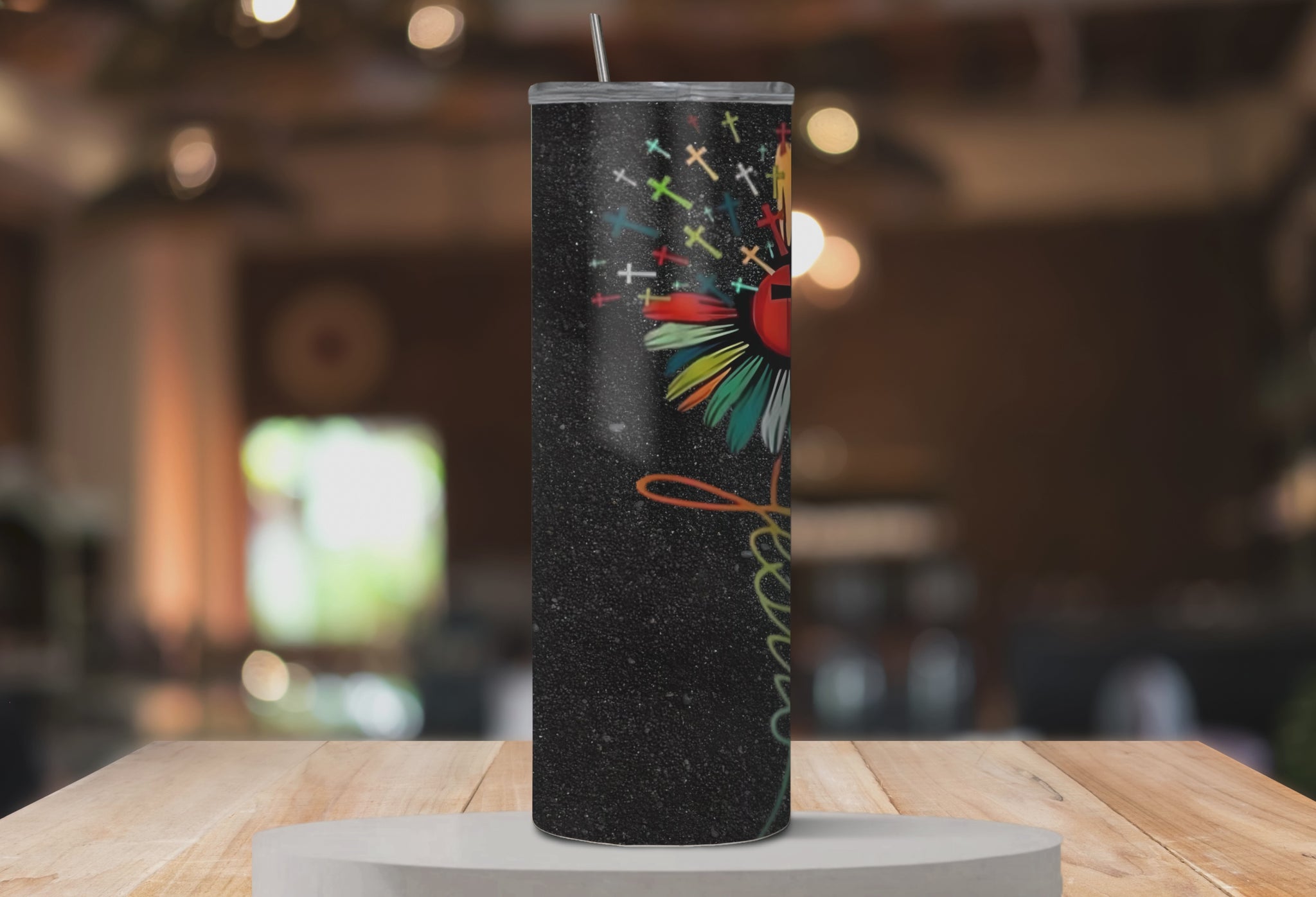 Rotating mockup of Bloom in Faith™ tumbler showing all sides of the colorful flower and cross design.